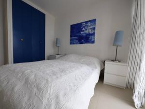 a white bedroom with a bed and two night stands at Appartement Palavas-les-Flots, 2 pièces, 4 personnes - FR-1-559-28 in Palavas-les-Flots