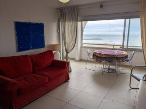 a living room with a red couch and a table at Appartement Palavas-les-Flots, 2 pièces, 4 personnes - FR-1-559-28 in Palavas-les-Flots