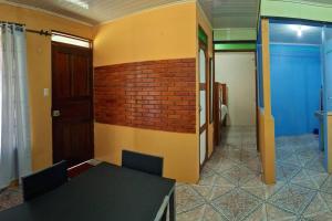 Zimmer mit einem Tisch und einer Ziegelwand in der Unterkunft Apartamento daly 1 in Guápiles