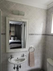 a bathroom with a sink and a mirror at Mulberry Gardens Self Catering in Swakopmund