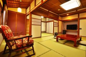 un soggiorno con sedia e tavolo di Ryokan Tanabe 旅館 田邊 a Takayama