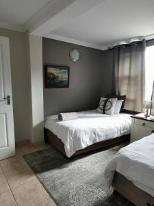 Un dormitorio con dos camas y un reloj en la pared. en Mulberry Gardens Self Catering, en Swakopmund 22 fotos más