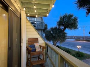 a porch with a chair and a view of a street at Paradise PRN in Gulf Shores
