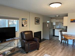 a living room with a chair and a table and a kitchen at The Chugach at 1400K in Anchorage