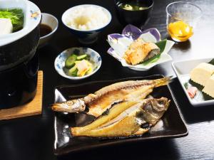 a table with a plate of food with fish and other dishes at Tango Onsen Hashiudosou in Kyotango