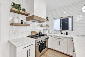 Una cocina blanca con estufa y fregadero. en Newly Built Modern Home w Ocean View Rooftop Deck, en Avalon 13 fotos más