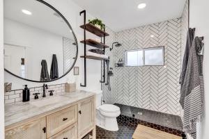 Un baño con lavabo, inodoro y espejo. en Newly Built Modern Home w Ocean View Rooftop Deck, en Avalon