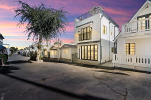 una casa blanca con una palmera en una calle en Newly Built Modern Home w Ocean View Rooftop Deck, en Avalon