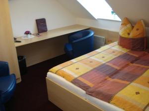 a room with a bed and a desk and a chair at Hotel Bierstübl in Sangerhausen