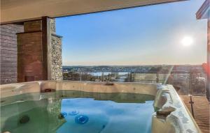 a large swimming pool in front of a large window at Stunning Home In Sandefjord With Jacuzzi in Sandefjord