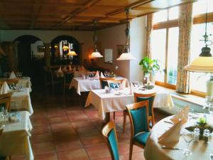 a restaurant with white tables and chairs and windows at Hotel Kreuz in Holderbank