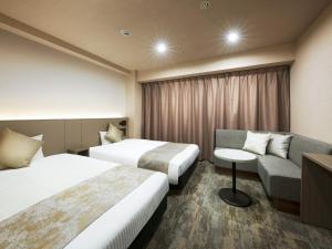 Habitación de hotel con 2 camas y sofá en Hotel Villa Fontaine Tokyo-Kayabacho, en Tokio