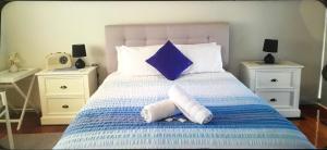 a bedroom with a blue and white bed with two night stands at Strathmore Lodge in Port Macquarie