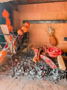 a grill with meat and other food on it at Chalé Casa de campo para família! in Urubici