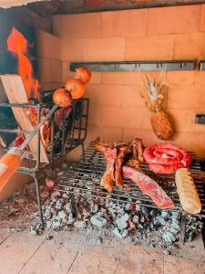 einen Grill mit Fleisch und anderen Lebensmitteln darauf in der Unterkunft Chalé Casa de campo para família! in Urubici