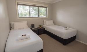 two beds in a small room with a window at Cardiff Executive Apartments in Newcastle