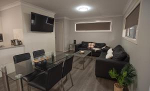 un soggiorno con divano e tavolo in vetro di Cardiff Executive Apartments a Newcastle