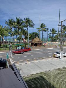 una strada con auto parcheggiate in un parcheggio vicino all'oceano di Pousada Maceió é Massa a Maceió