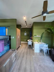 sala de estar con paredes verdes y ventilador de techo. en Modern apartment 01, en Panamá