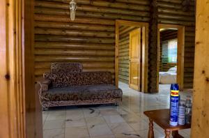 un soggiorno con divano e tavolo di Log Cabin House a Lutong