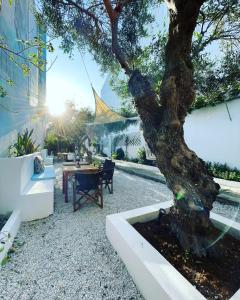 un patio con una mesa y un árbol en Akti Posidonos 3 en Eloúnda