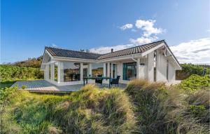 een klein wit huis met een terras op het strand bij Beautiful Home In Lkken With 3 Bedrooms, Sauna And Wifi in Grønhøj