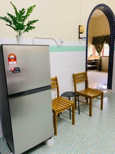 Kampong Bukit KatilにあるBella Homestay Melakaの冷蔵庫、椅子2脚が備わります。