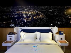 uma cama num quarto com uma fotografia de uma cidade em Airline Inn Green Park Way em Taichung