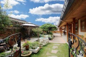 an outdoor patio with an umbrella and some plants at Moran Guesthouse in Jeonju