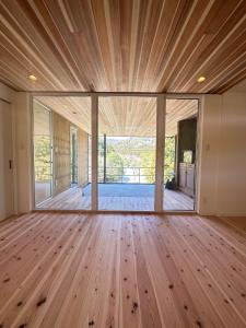 a large room with a wooden floor and large windows at Ayu House - Vacation STAY 03971v in Nagahama