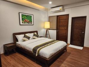 - une chambre avec un lit et une lampe dans l'établissement The Bedrooms Maeklong and Services Apartment, à Samut Songkhram