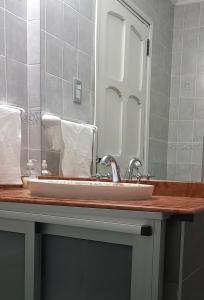 um balcão de casa de banho com um lavatório e um espelho em imanalla em Salta
