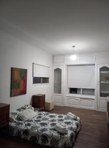 um quarto branco com uma cama e uma janela em imanalla em Salta