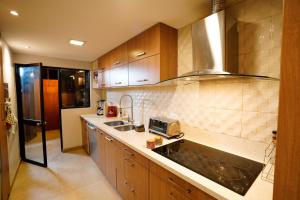 a kitchen with a sink and a stove at Apartamento con jacuzzi y Parqueadero in Cuenca