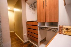 una pequeña cocina con nevera y armarios de madera. en Apartamento con jacuzzi y Parqueadero, en Cuenca