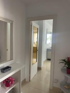 a bathroom with a sink and a mirror and a door at Remarkable 3-Bed Apartment in Chipiona in Chipiona