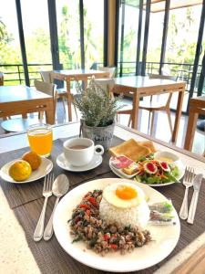 a table with a plate of food with eggs and rice at Wangpruksa Resort in Ban Nong Bua