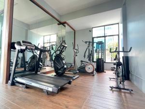 a gym with several exercise bikes and a mirror at The Bedrooms Maeklong and Services Apartment in Samut Songkhram
