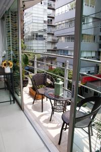 Un patio con sillas y una mesa en el balcón. en D HABITACION MANDALA NEBRASKA 63, en Ciudad de México