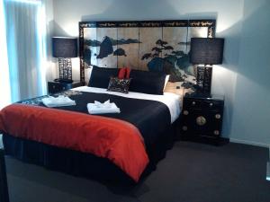 a bedroom with a large bed with shoes on it at Sovereign Pier On The Waterways in Whitianga