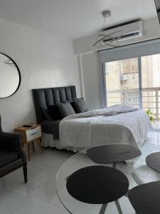 a bedroom with a bed and a chair and a window at Buenos Aires City in Buenos Aires