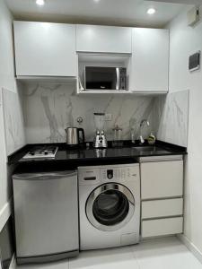 a kitchen with a washing machine and a microwave at Buenos Aires City in Buenos Aires
