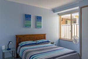 a bed in a room with a window and a bed sidx sidx sidx at Peaceful Cul de sac in Sussex Inlet