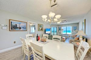 a dining room and living room with a white table and chairs at Anna Maria Island Beach Sands 201 in Bradenton Beach