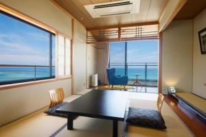 a dining room with a table and a view of the ocean at シーサイド佐竹 in Kyotango