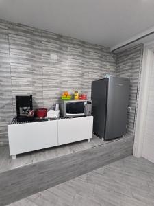 a kitchen with a microwave and a refrigerator at B&B Vicolo50 Salerno in Salerno