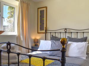 1 dormitorio con cama con almohadas y ventana en Thornes Farm Annexe, en West Quantoxhead