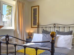 a bedroom with a bed with pillows and a window at Thornes Farm Annexe in West Quantoxhead