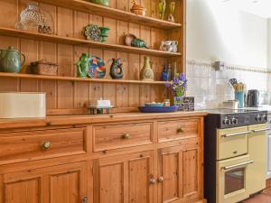 a kitchen with wooden cabinets and a stove at Thornes Farm Annexe in West Quantoxhead