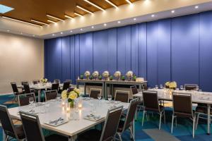 une salle de conférence avec des tables et des chaises devant un mur bleu dans l'établissement Element Harrison-Newark, à Harrison